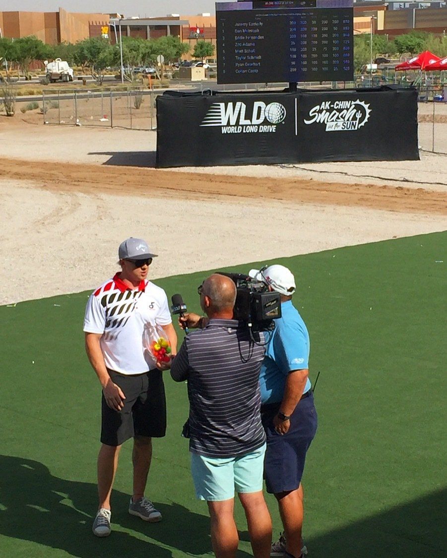 Two men are standing in front of a sign that says wld
