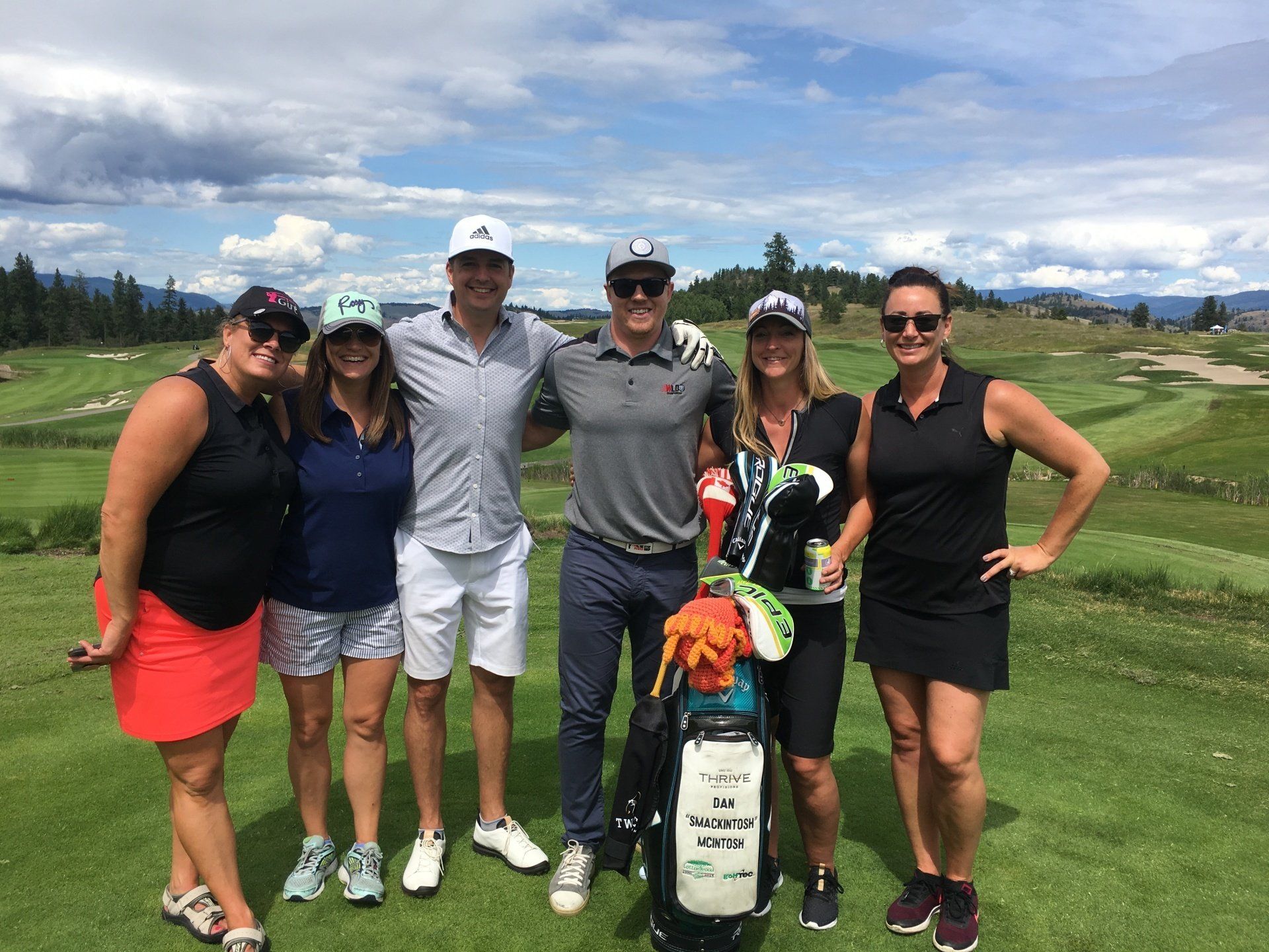 A group of people are posing for a picture on a golf course.