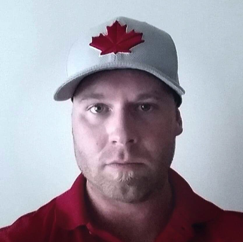 A man wearing a hat with a maple leaf on it