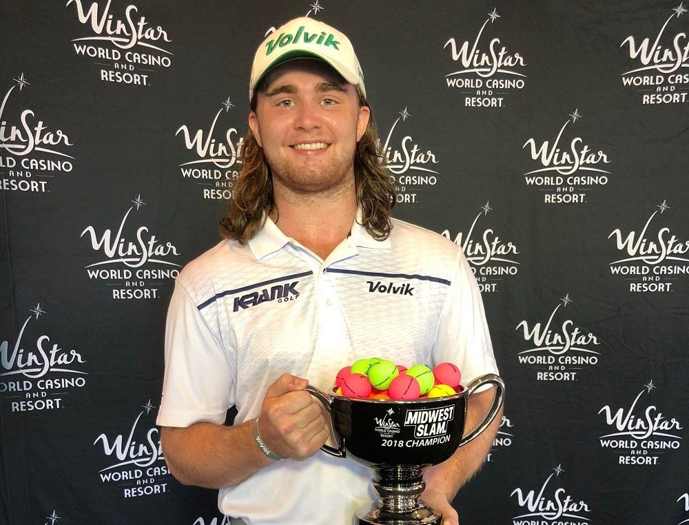 Golfer holding trophy, smiling in front of a WinStar World Casino Resort backdrop, with colorful golf balls.