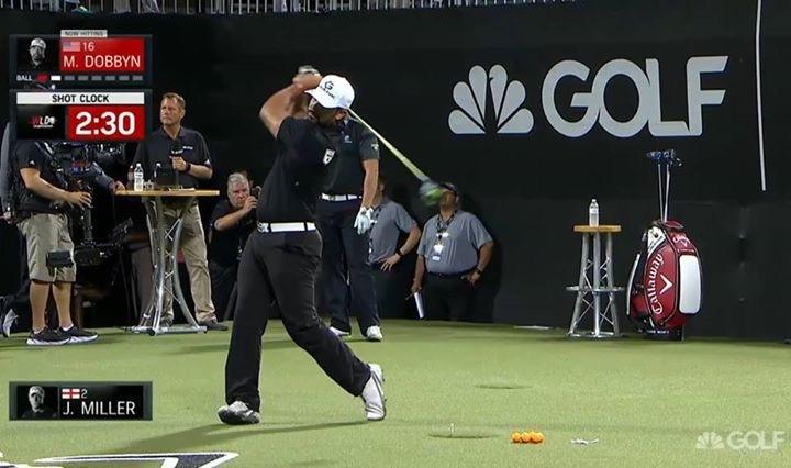 A man is swinging a golf club in front of a sign that says golf