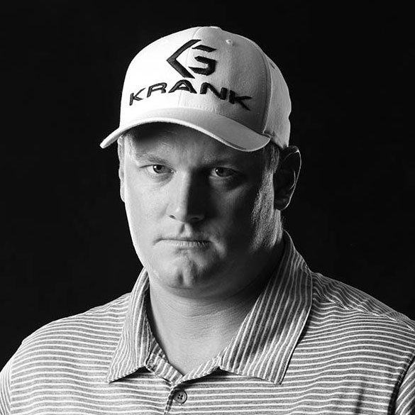 A black and white photo of a man wearing a baseball cap.