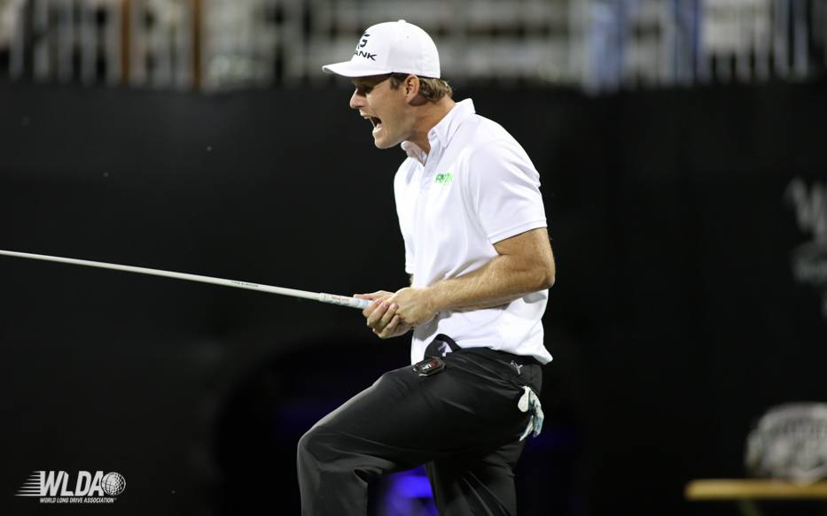 A man in a white shirt and hat is holding a rope