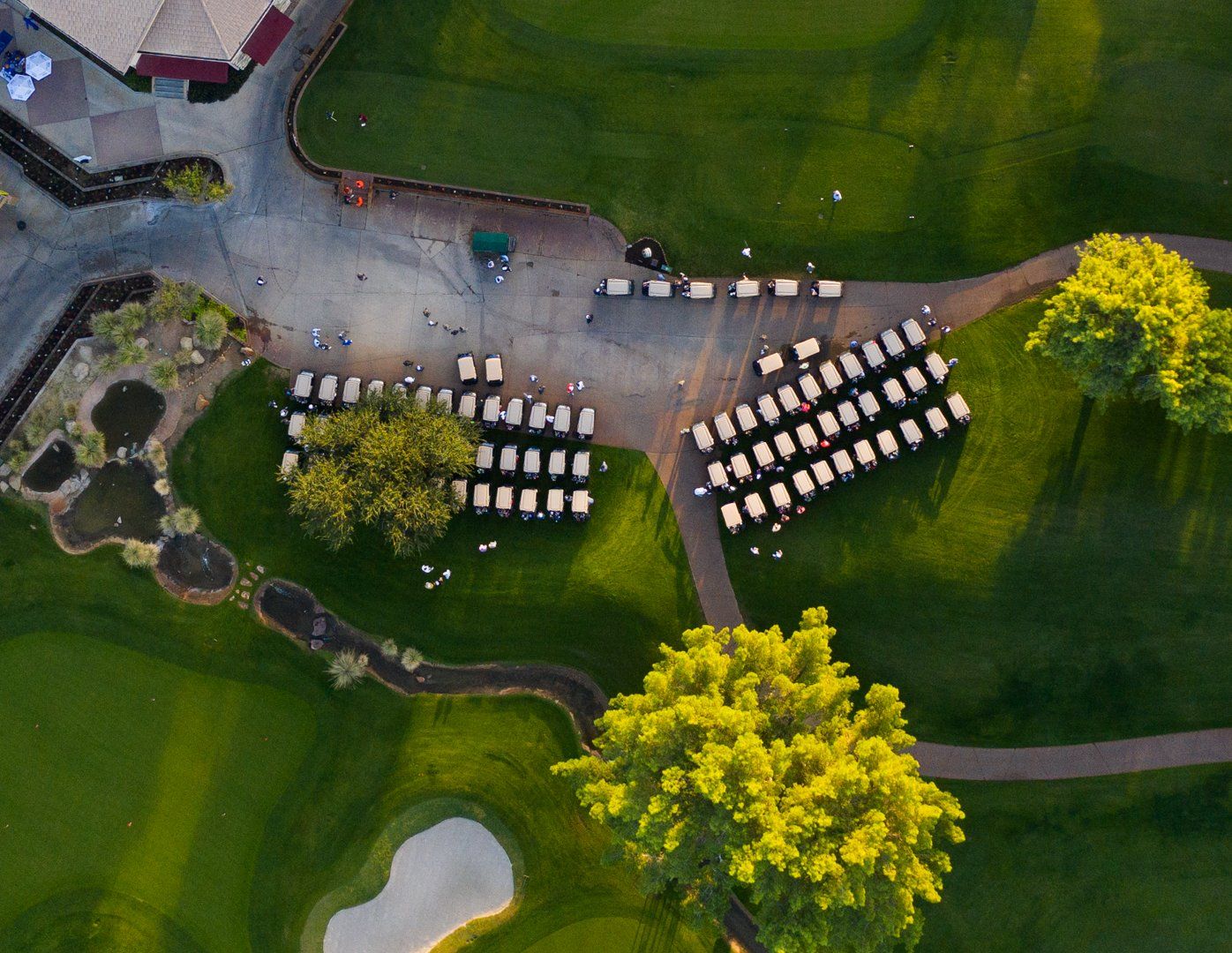 An aerial view of a golf course with a row of chairs in the grass.