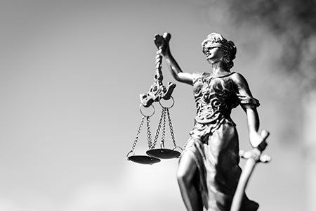 una statua che tiene in mano una bilancia a due piatti