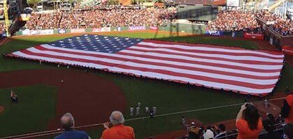 Large Group Travel — Huge Size Of American Flag In Baseball Field  in Castroville, CA