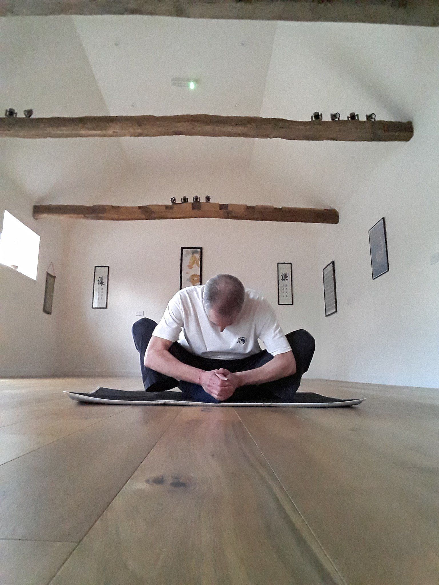 The Balanced Path At The Tai Chi Studio instructor Dave in sitting down, head bowed, legs crossed position