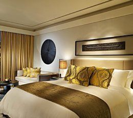 A hotel room with a king size bed and a couch.