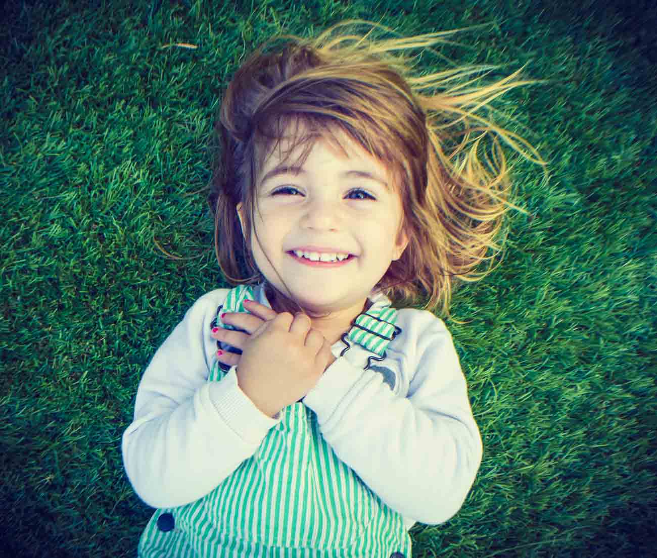 little girl laying on the grass