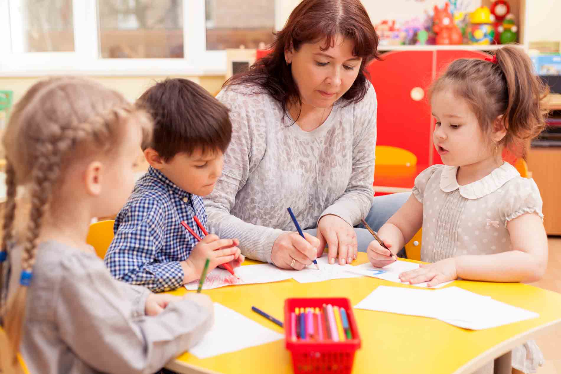 Little kids writing at a table little kids writing at a table
