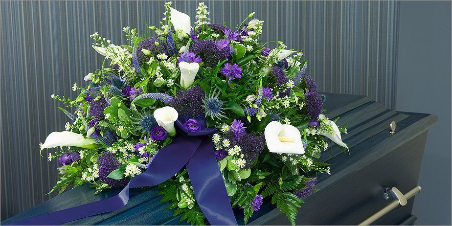 A flower arrangement on top of a coffin