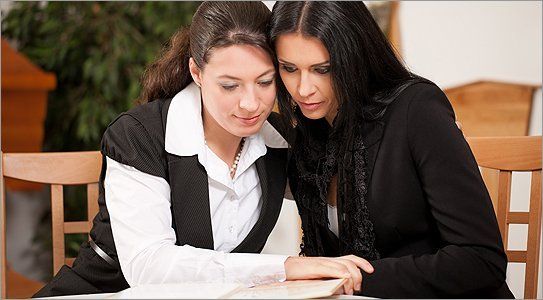Two women looking through a book