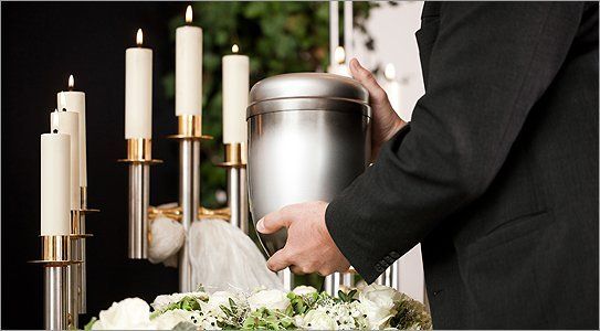 A man holding an urn near candles
