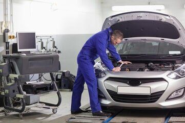 Man Checking Car Engine – Auto Repair Shop in Maryville, MO Man Checking Car Engine – Auto Repair Shop in Maryville, MO