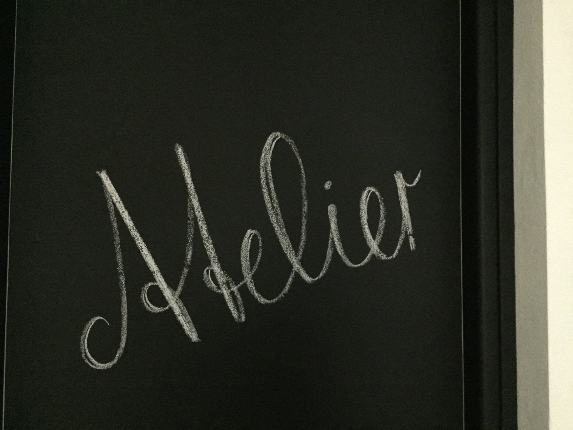 Pannello con la parola Atelier in calligrafia