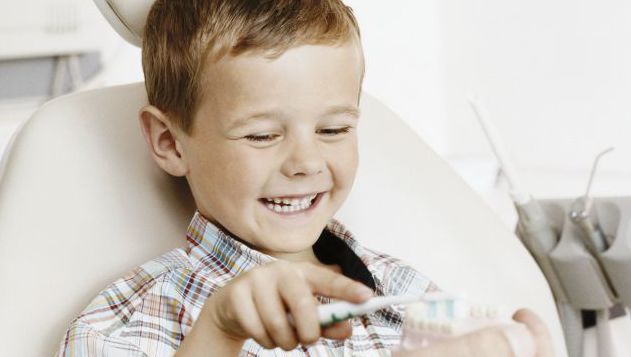 Happy kid is brushing dummy teeth