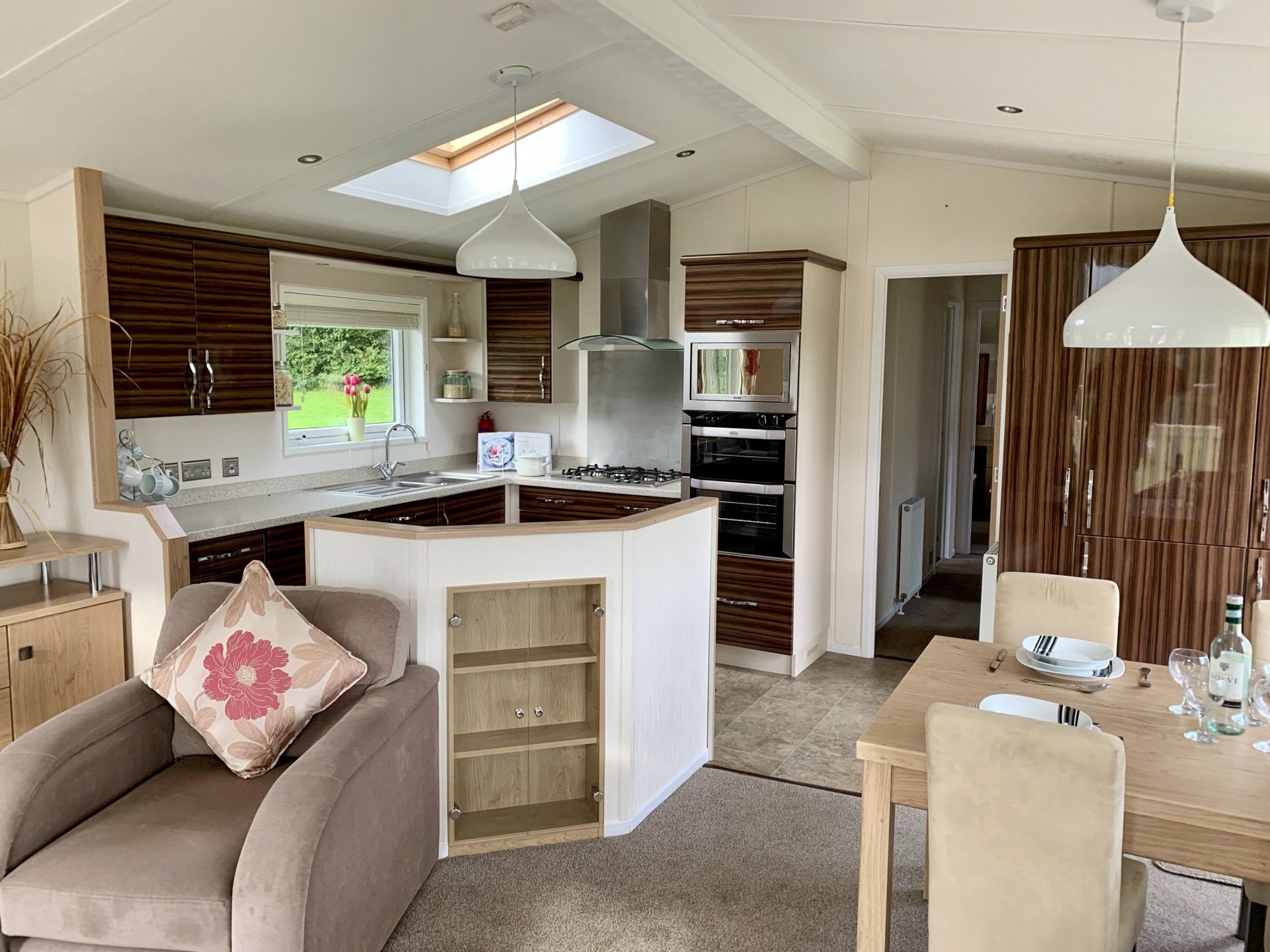 A living room with a dining table and chairs and a kitchen.