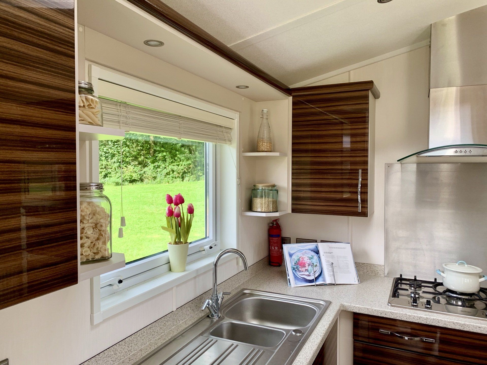 A kitchen with a sink , stove , and window.