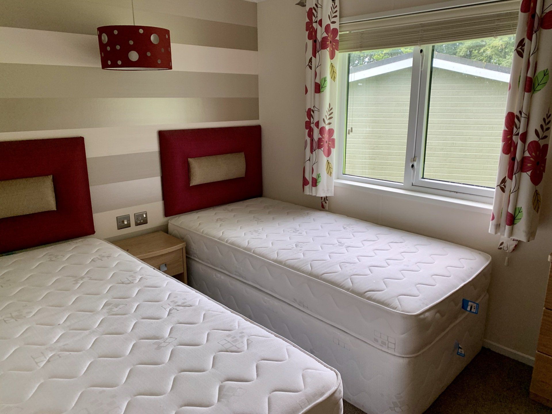 A bedroom with two beds and a window.