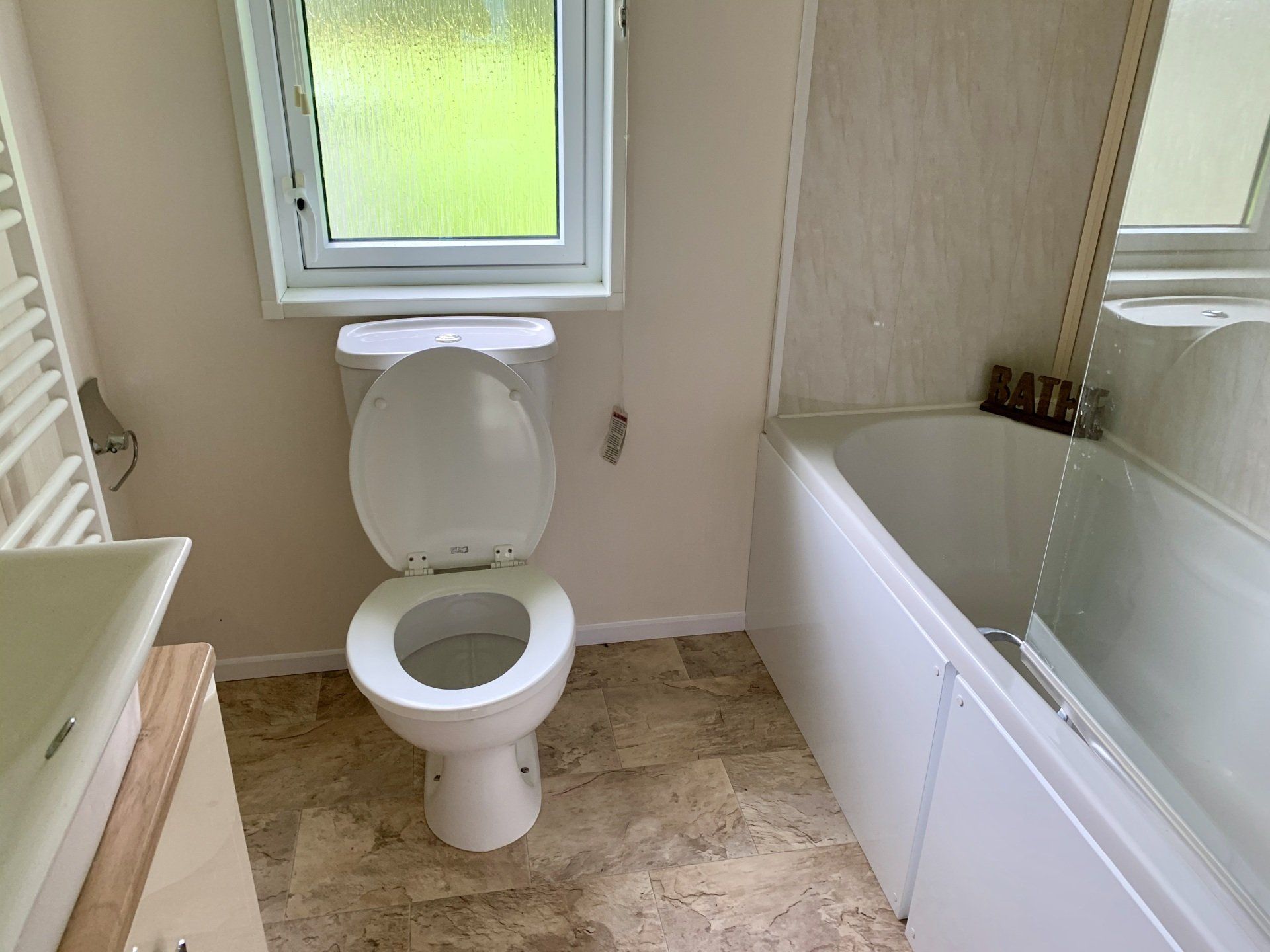 A bathroom with a toilet , sink and bathtub.