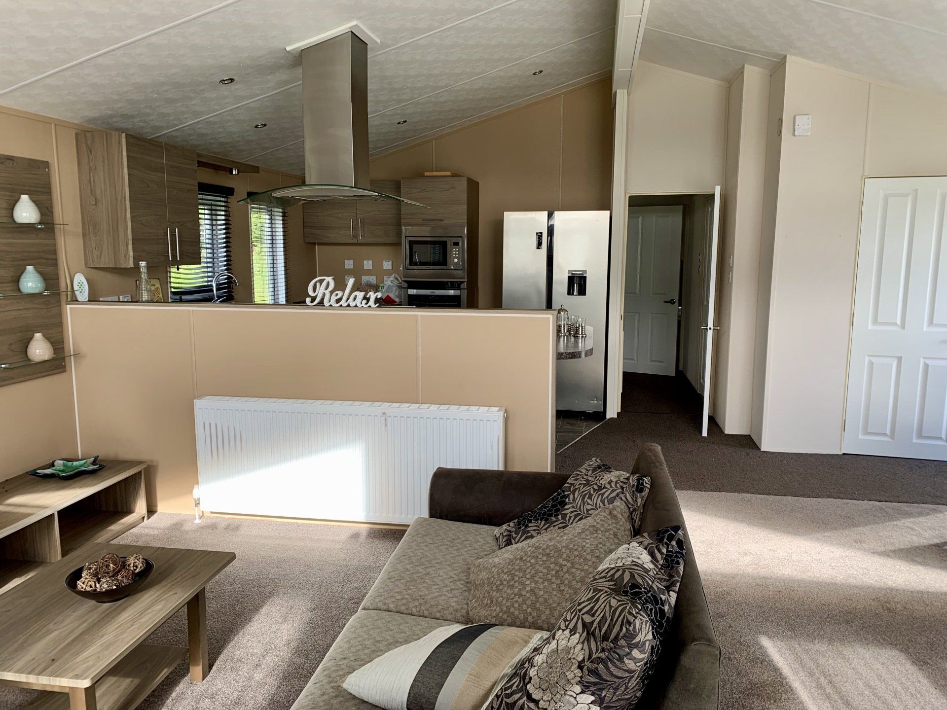 A living room with a couch , coffee table , and refrigerator.