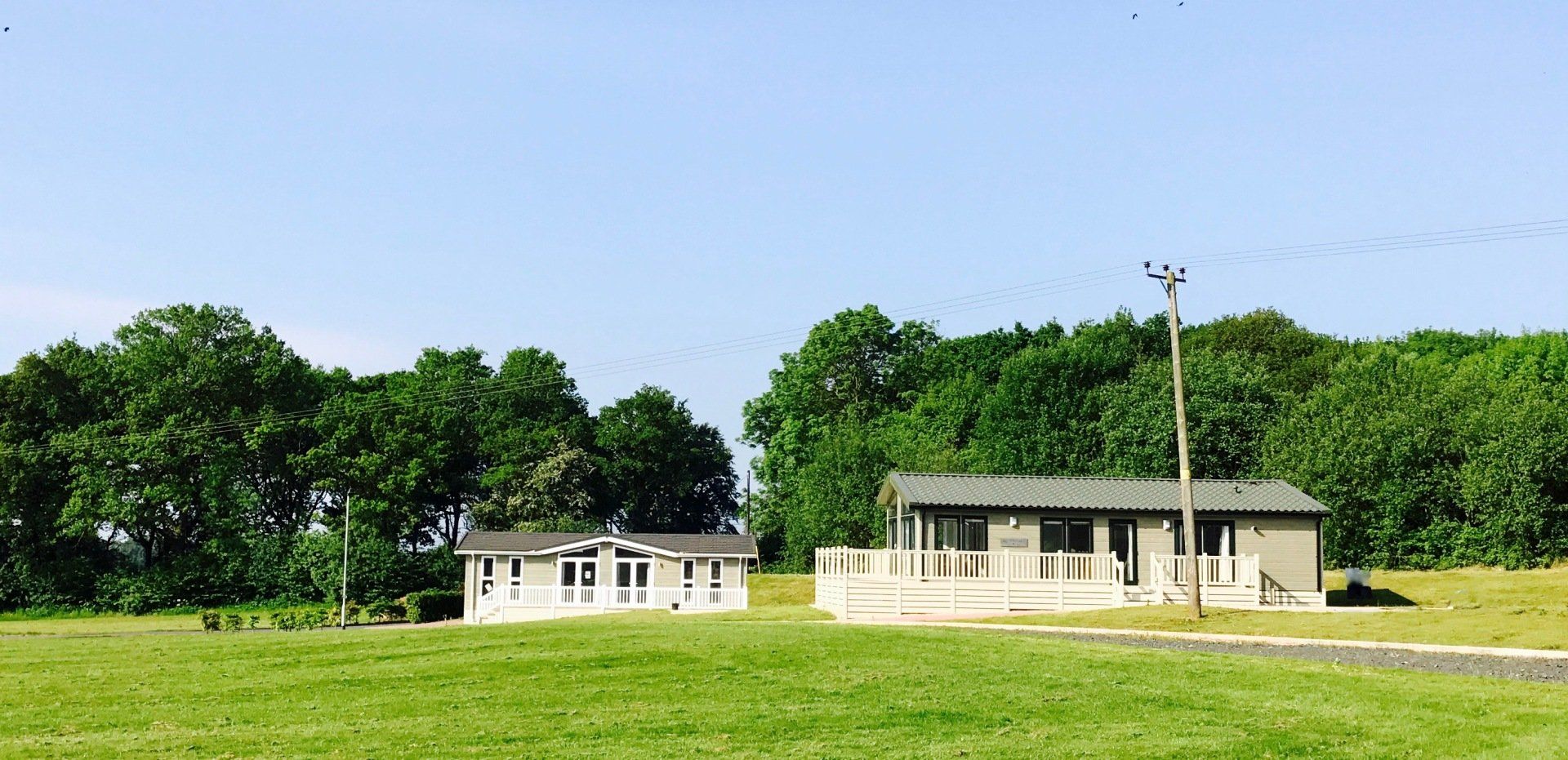 Two houses are sitting in the middle of a grassy field.