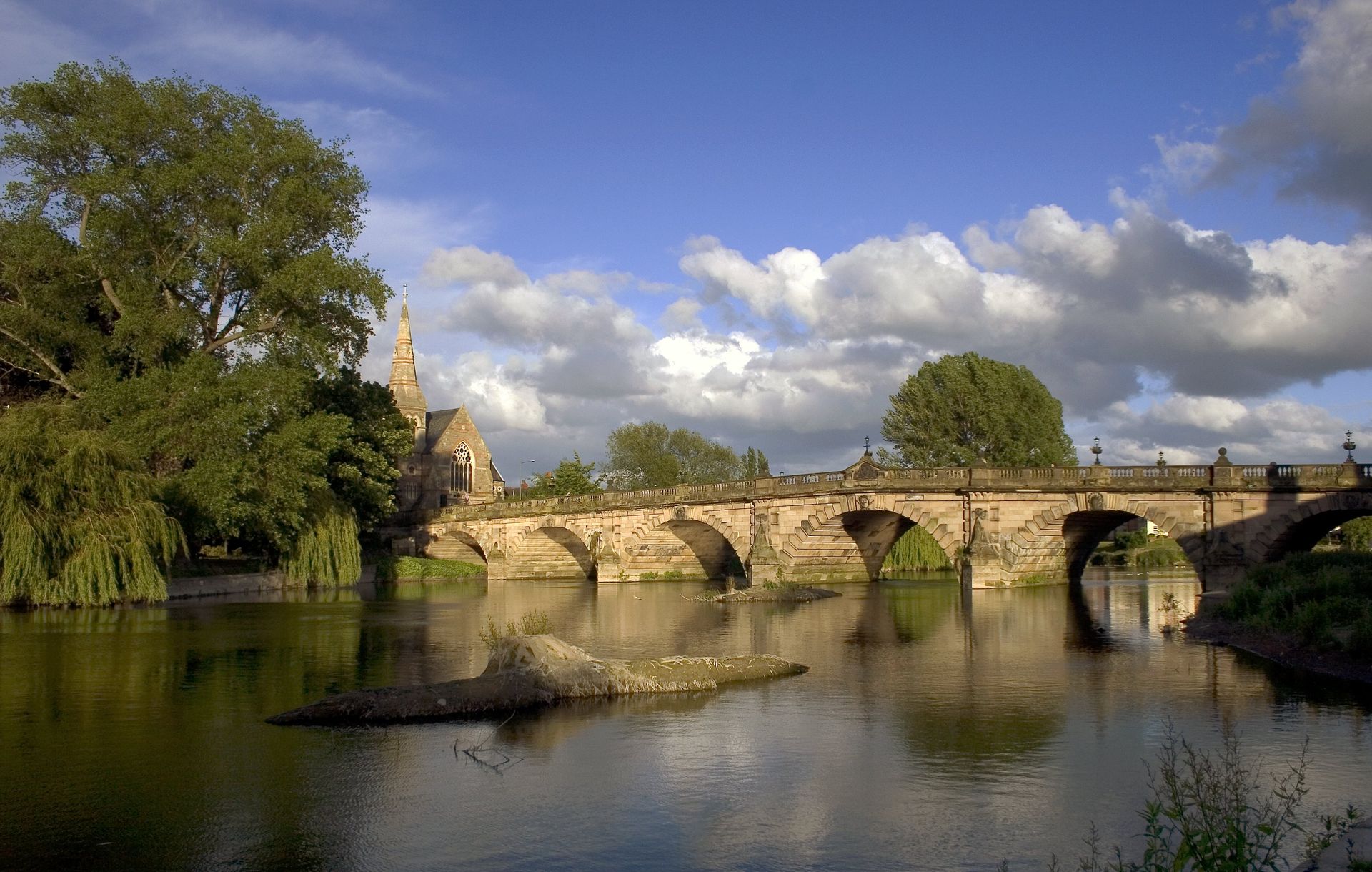 A bridge over a body of water with trees in the background