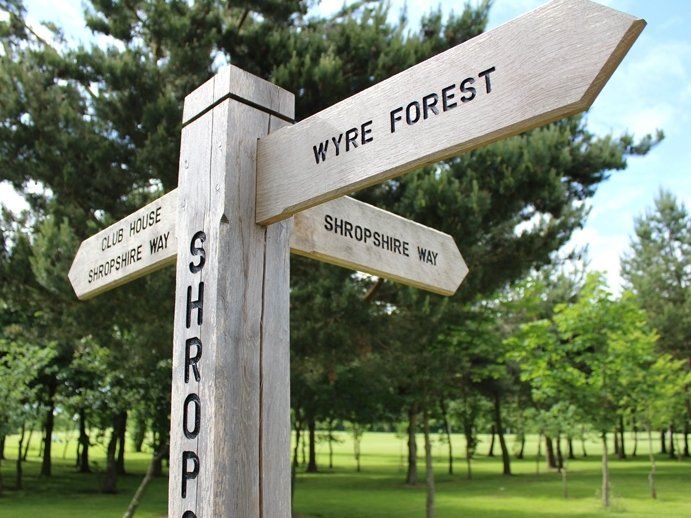 A wooden sign points to wyre forest and shroping