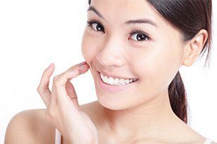 Young smiling woman hand touch her mouth—Established Dentistry Center in Fountain Valley, California Young smiling woman hand touch her mouth—Established Dentistry Center in Fountain Valley, California