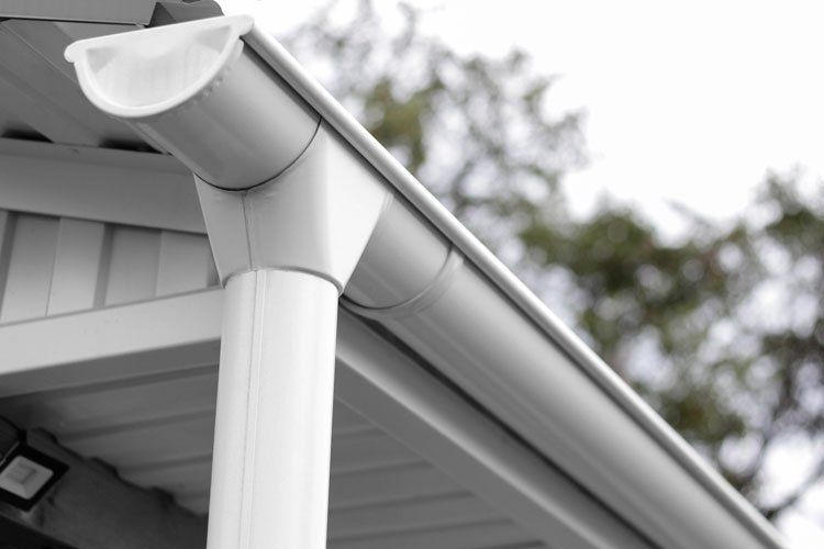 Gutter on the side of a house cleaned by wiz home services