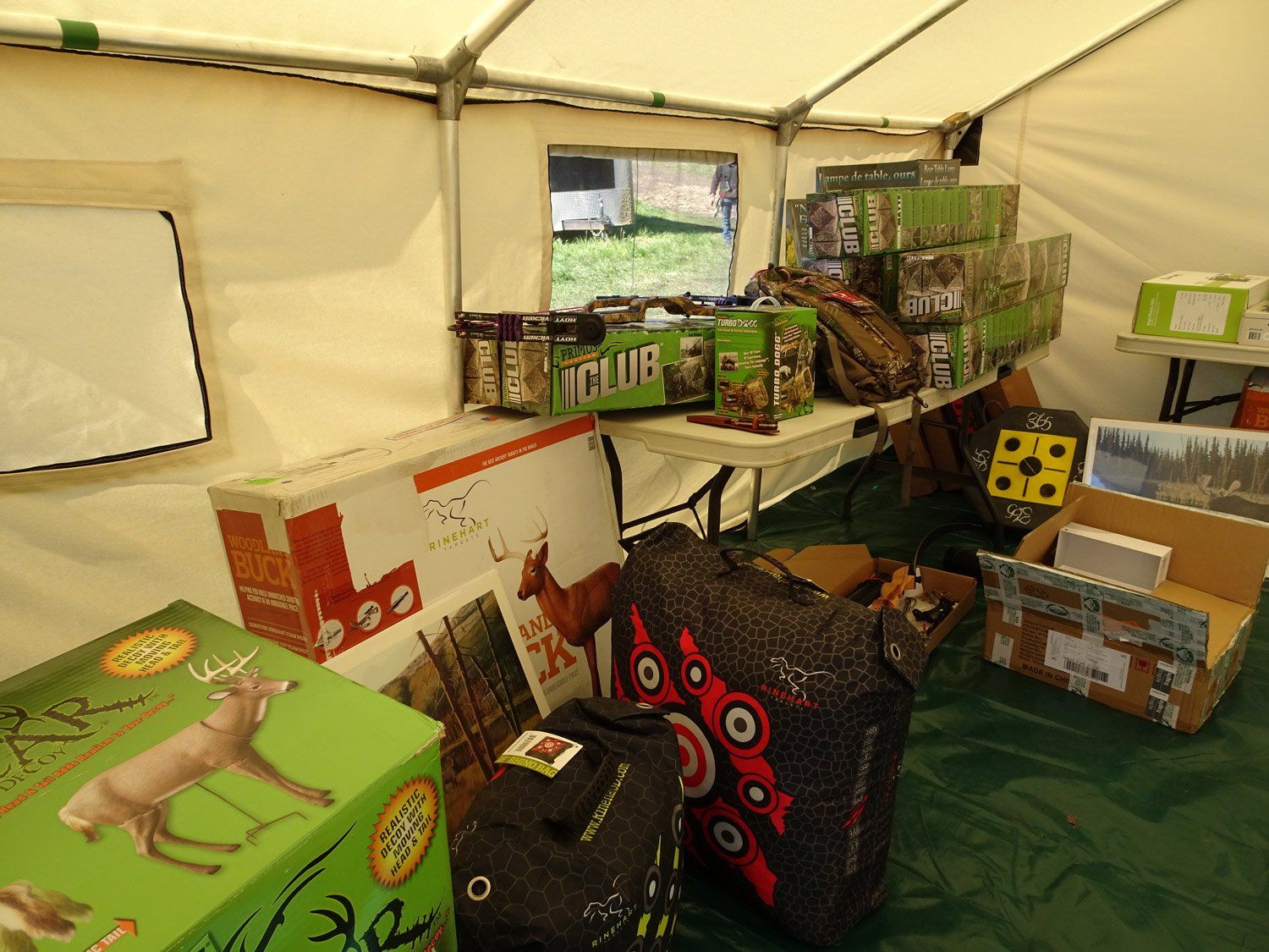 A green box with a deer on it sits under a tent