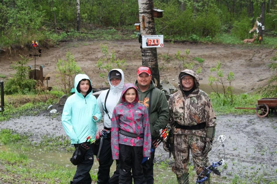 A group of people are posing for a picture in the rain.