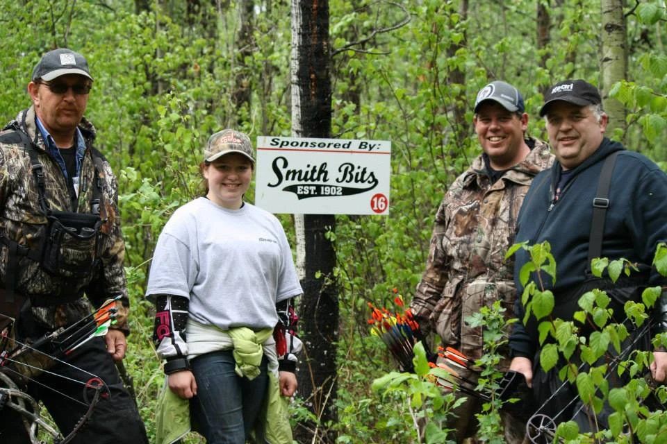 A group of people standing in front of a sign that says smith bits