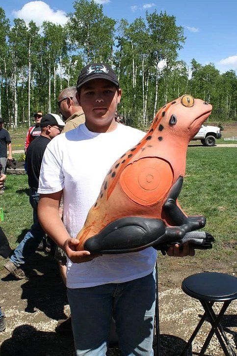 A man is holding a target in the shape of a frog.