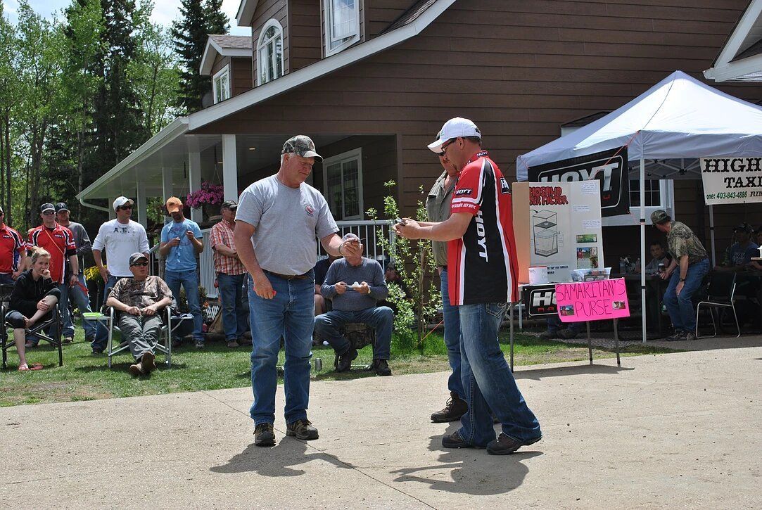A man is shaking hands with another man in front of a house.