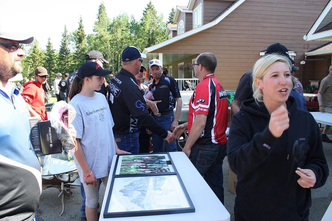 A group of people are standing around a table talking to each other