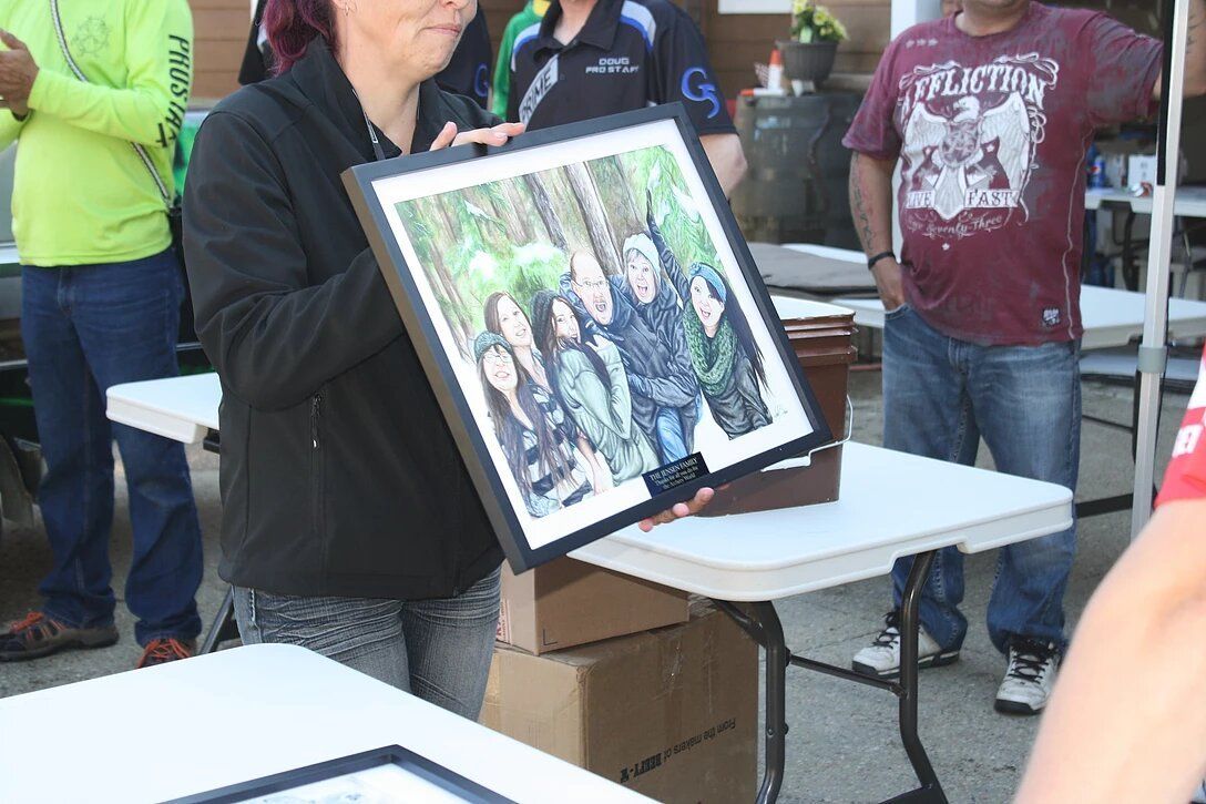 A woman is holding a framed picture of a family.