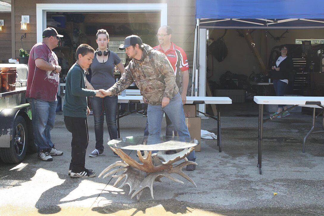 A group of people shaking hands in front of a table