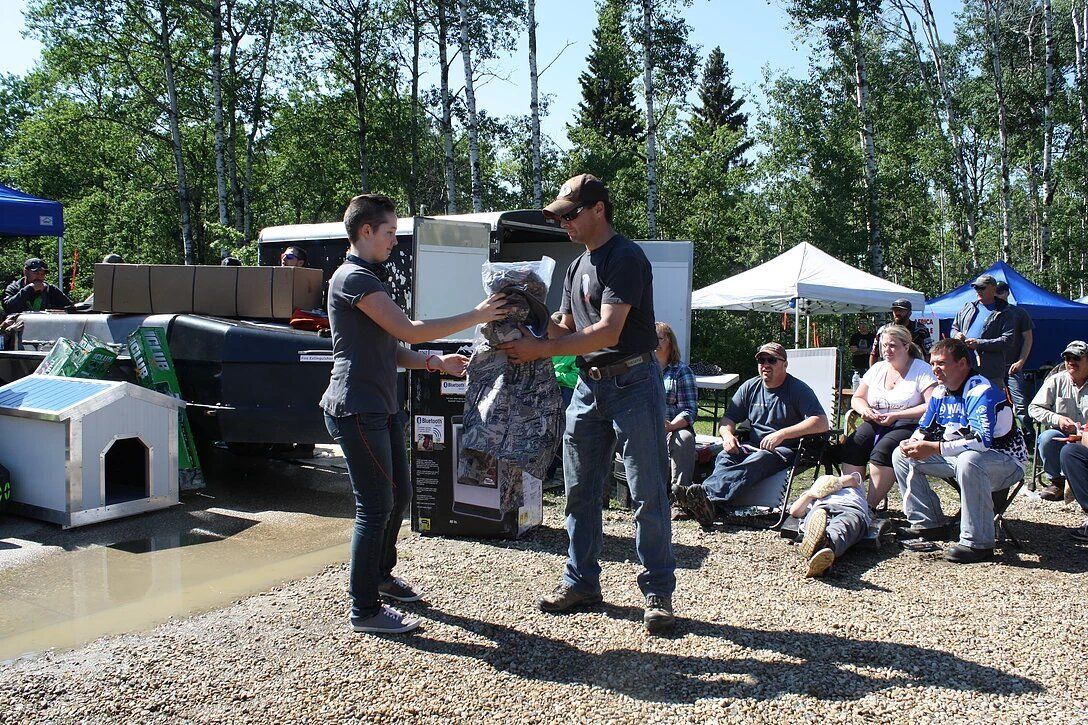 A man and a woman are standing next to each other in a gravel area.