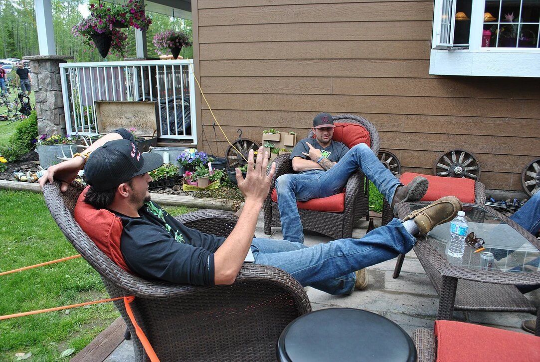 A man is sitting in a chair on a patio with his feet up.