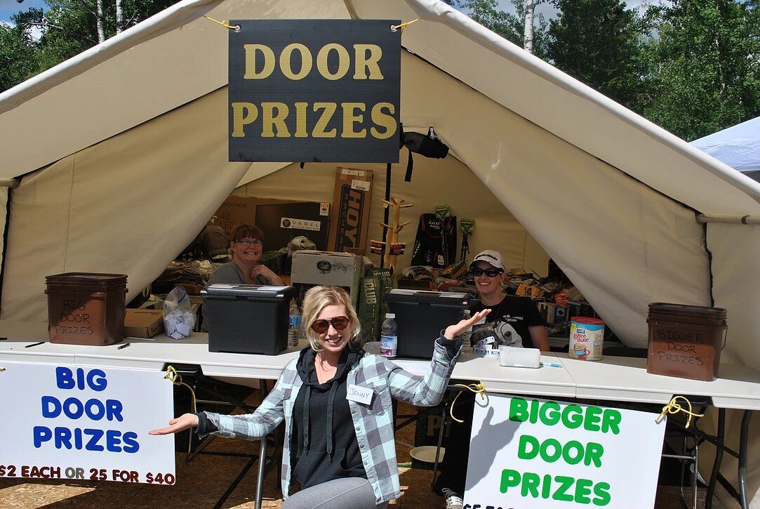 A woman stands in front of a tent that says door prizes