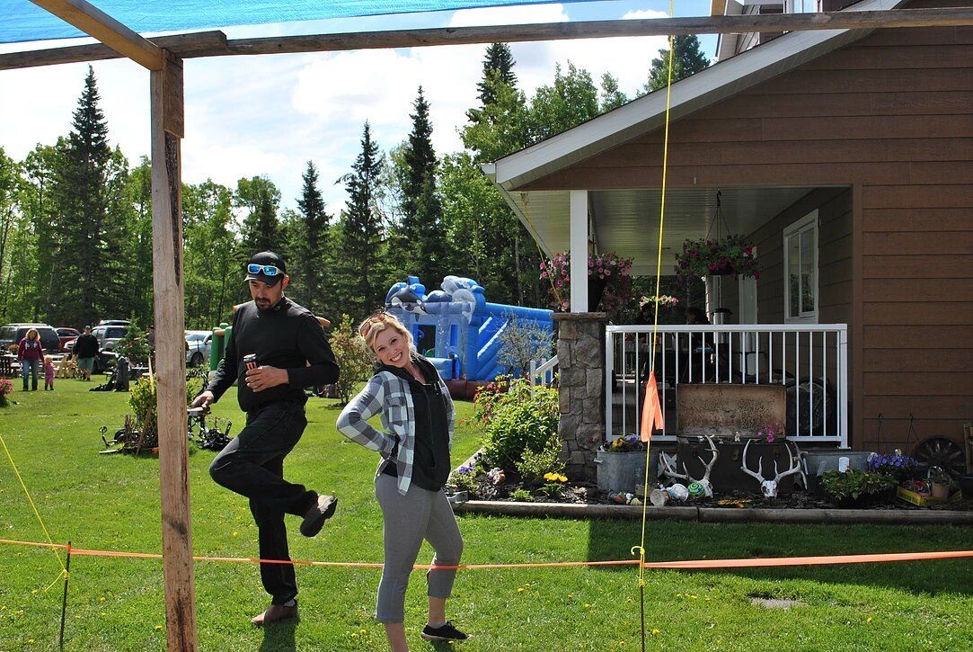 A man and a woman are standing in front of a house.