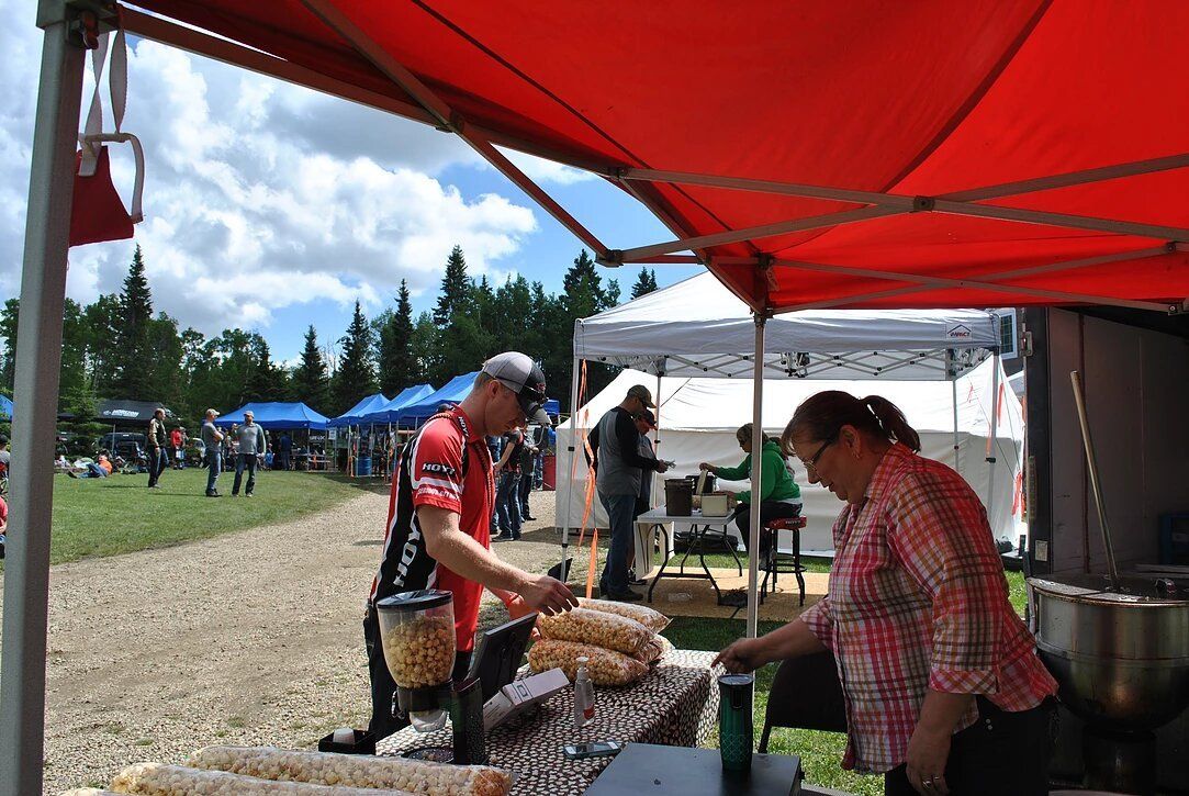 A man and a woman are standing under a red tent.