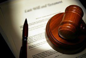 A pen, hammer and gavel on top of legal documents