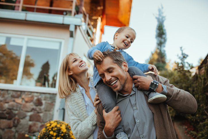 happy family in front of their home — Insurance Agents in South New Jersey happy family in front of their home — Insurance Agents in South New Jersey