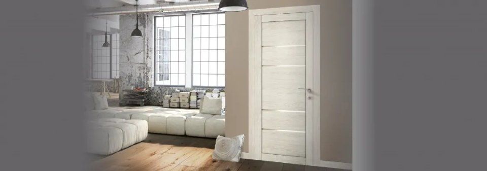 Camera da letto luminosa con porta, finestra e letto a pannelli bianchi, in un ambiente interno dai toni neutri e delicati.