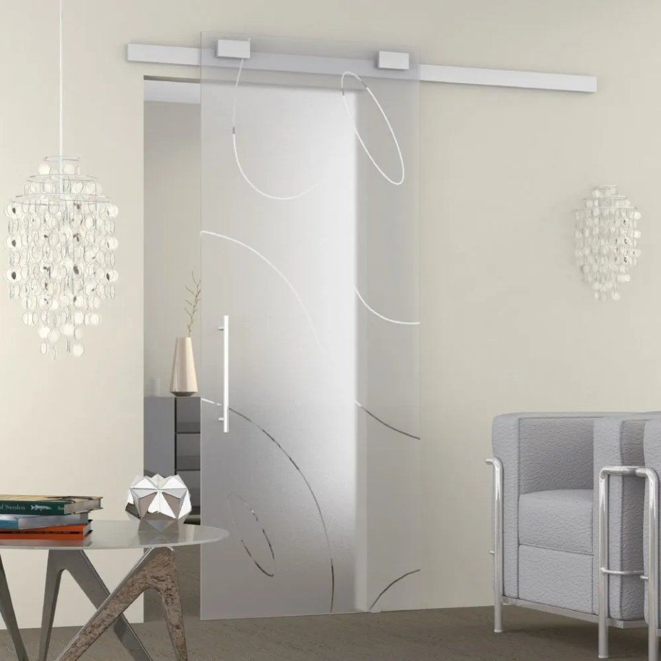 Soggiorno moderno con porta scorrevole satinata, lampadario e divano grigio.