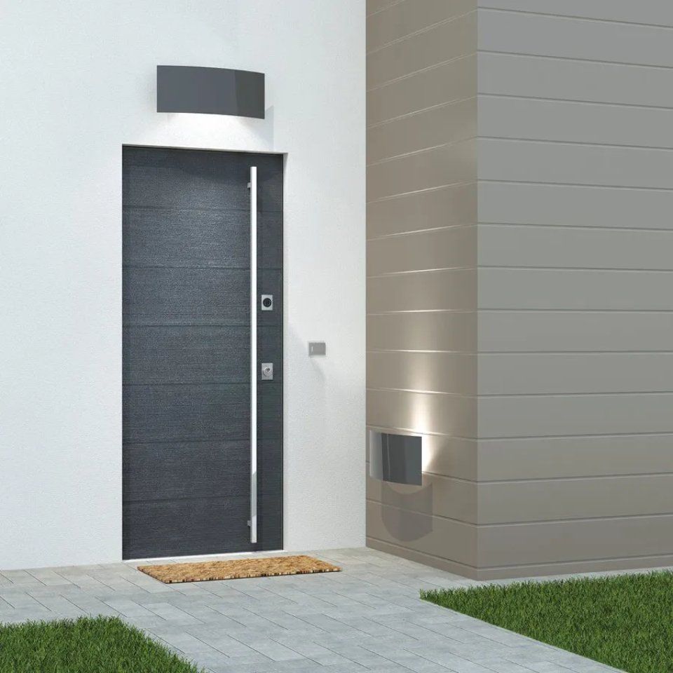 Porta d'ingresso nera moderna con finestre laterali su un esterno di casa minimalista con rivestimento grigio e zerbino
