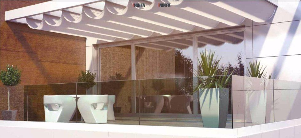 Patio moderno con pergola bianca, muro in mattoni, ringhiera in vetro e piante in vaso su una terrazza a bordo piscina.