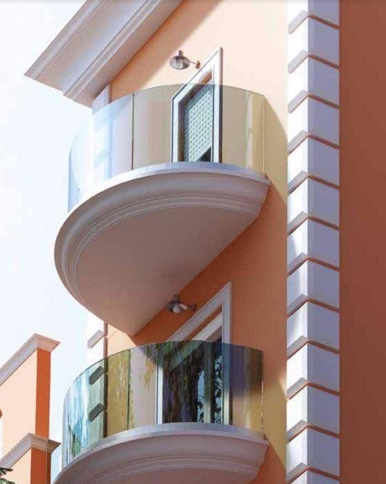 Facciata moderna di un appartamento color pesca con balconi curvi e finiture bianche.